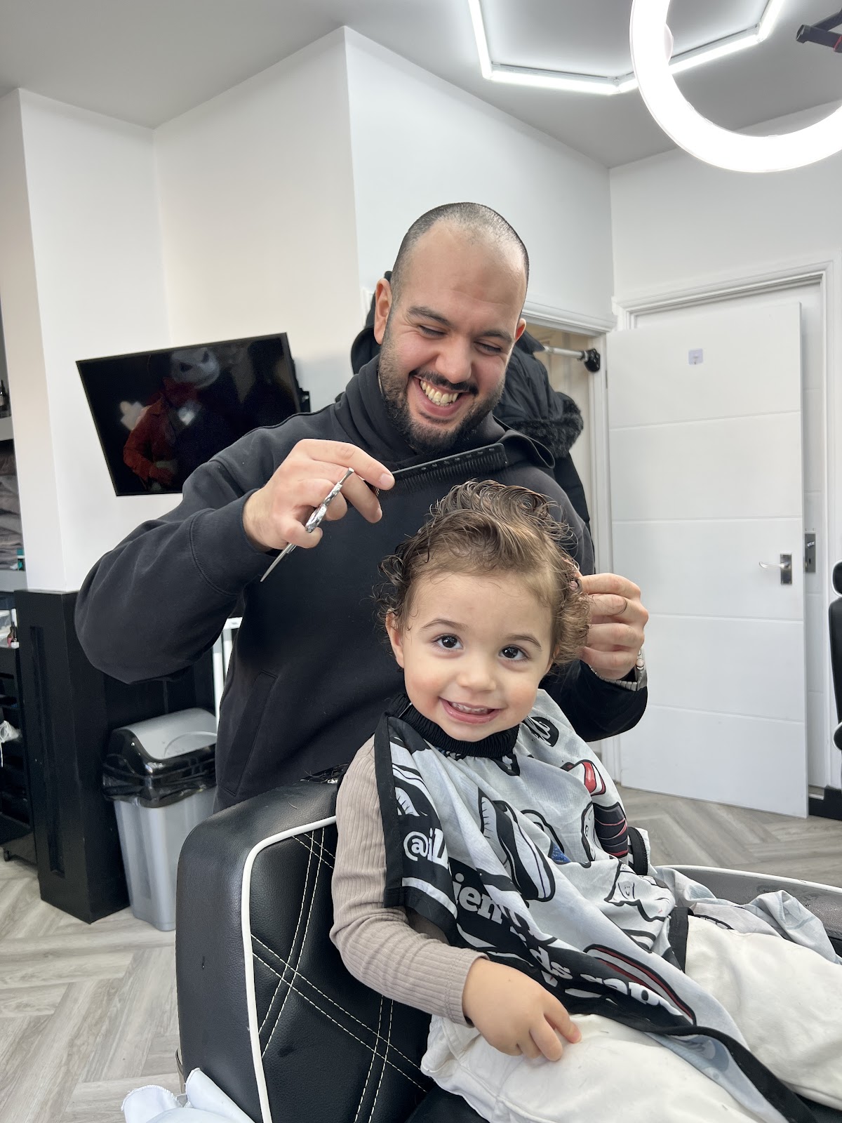 Child getting a haircut at Emin's Barbershop